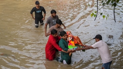People carry an idol of Lord Ganesh after the water from the raging Yamuna river flooded the area, near Yamuna Bazar, in New Delhi. (PTI) People carry an idol of Lord Ganesh after the water from the raging Yamuna river flooded the area, near Yamuna Bazar, in New Delhi. (PTI)