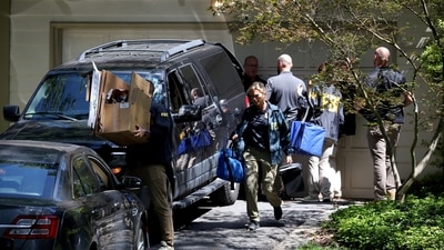 FBI agents carry boxes outside the home of the former White House national security adviser John Bolton as it is searched in August this year (REUTERS)