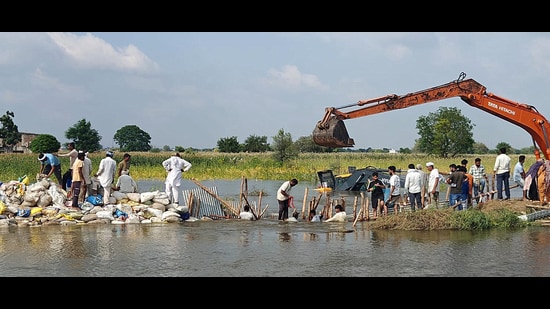 Farmers making a bundh to stop water from entering houses in Hisar on Friday. (Manoj Dhaka/HindustanTimes)