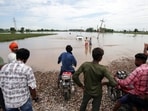 People try to cross a flooded area near village Gago Mahal at the border area of Ajnala, on Friday. People try to cross a flooded area near village Gago Mahal at the border area of Ajnala, on Friday.