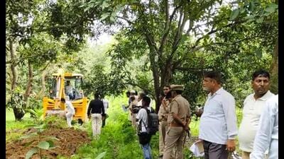 A bulldozer in action at the orchard of SP MLA in Firozabad on Saturday. (HT)