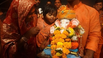 A family smiles and soaks in the last glance of its beloved Ganpati Bappa in Thane today, as devotees eagerly await his arrival again next year. (Praful Gangurde/Hindustan Times) A family smiles and soaks in the last glance of its beloved Ganpati Bappa in Thane today, as devotees eagerly await his arrival again next year. (Praful Gangurde/Hindustan Times)