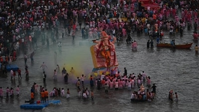 Devotees carry a giant idol of Lord Ganesh into the sea for immersion as people crowd the shore to bid farewell to their beloved deity. (Raju Shinde/Hindustan Times) Devotees carry a giant idol of Lord Ganesh into the sea for immersion as people crowd the shore to bid farewell to their beloved deity. (Raju Shinde/Hindustan Times)