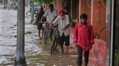 Pedestrians are seen wading though a flooded road after Yamuna overflowed in Delhi following heavy rain. (Manish Swarup/AP) Pedestrians are seen wading though a flooded road after Yamuna overflowed in Delhi following heavy rain. (Manish Swarup/AP)