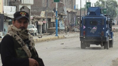 A police officer stands guard on a street with damaged shops in the background, following a militant attack on the Frontier Constabulary (FC) headquarters in Bannu, Khyber Pakhtunkhwa province, in Pakistan. REUTERS/Ehsan Khattak (REUTERS)