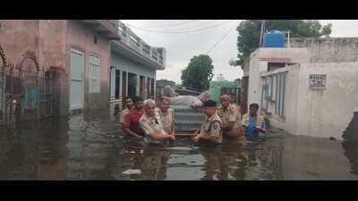 Police and locals rescuing an elderly in Bhiwani’s Sagwan village on Saturday. (HT Photo) Police and locals rescuing an elderly in Bhiwani’s Sagwan village on Saturday. (HT Photo)