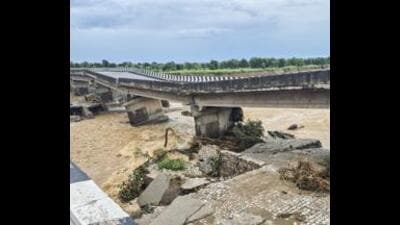 Portion of a bridge on the Jammu-Pathankot national highway gets damaged due to overflowing of Sahar Khad nallah following heavy rainfall, in Kathua, on Sunday.A Hindu family has provided shelter to a Muslim family in Kathua’s Bani area whose house was damaged in a flash flood on August 28. (PTI)