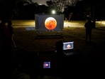 People watch on a video beam screen a full moon during a "Blood Moon" total lunar eclipse, at an overnight camp at the Humboldt Planetarium, in Caracas, Venezuela March 14, 2025. People watch on a video beam screen a full moon during a "Blood Moon" total lunar eclipse, at an overnight camp at the Humboldt Planetarium, in Caracas, Venezuela March 14, 2025.