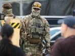 Immigration and Customs Enforcement (ICE) agents stand guard as demonstrators protest outside of an ICE processing facility. Immigration and Customs Enforcement (ICE) agents stand guard as demonstrators protest outside of an ICE processing facility.
