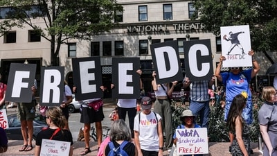 Demonstrators with ‘Free DC’ posters during a protest against the National Guard troops' deployment in the city (Bloomberg)