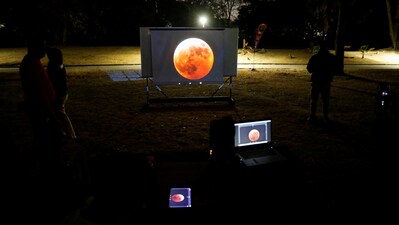 People watch on a video beam screen a full moon during a "Blood Moon" total lunar eclipse, at an overnight camp at the Humboldt Planetarium, in Caracas, Venezuela March 14, 2025. (Reuters File)