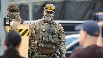 Immigration and Customs Enforcement (ICE) agents stand guard as demonstrators protest outside of an ICE processing facility. (Bloomberg) Immigration and Customs Enforcement (ICE) agents stand guard as demonstrators protest outside of an ICE processing facility. (Bloomberg)