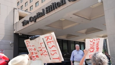 A man stands at a Hilton hotel, as demonstrators attend the "We Are All DC" march to protest against National Guard troops in Washington, D.C. (Reuters)