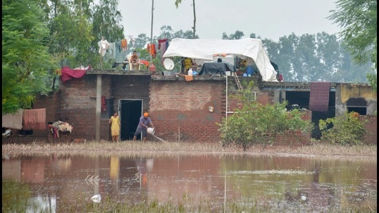 A man drains the flooded water from their house at village Machhiwala near Ramdas in Amritsar on Sunday. (Sameer Sehgal/Hindustan Times)