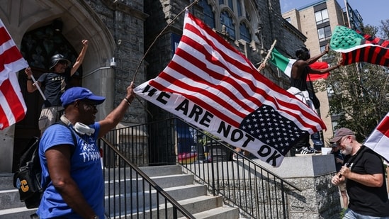 Demonstrators were seen waving inverted US flags to protest against the deployment of more than 2,000 troops from six Republican-led states in Washington DC(Bloomberg)