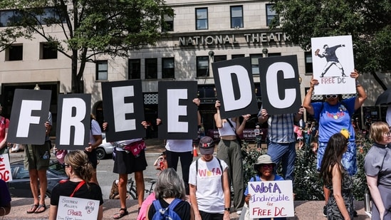 Demonstrators with ‘Free DC’ posters during a protest against the National Guard troops' deployment in the city(Bloomberg)