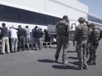 This image from video provided by U.S. Immigration and Customs Enforcement via DVIDS shows manufacturing plant employees waiting to have their legs shackled at the Hyundai Motor Group’s electric vehicle plant, Thursday, Sept. 4, 2025, in Ellabell, Ga. (Corey Bullard/U.S. Immigration and Customs Enforcement via AP) This image from video provided by U.S. Immigration and Customs Enforcement via DVIDS shows manufacturing plant employees waiting to have their legs shackled at the Hyundai Motor Group’s electric vehicle plant, Thursday, Sept. 4, 2025, in Ellabell, Ga. (Corey Bullard/U.S. Immigration and Customs Enforcement via AP)