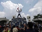 A demonstrator waves a flag as he stands atop a vehicle near the entrance of the Parliament during a protest against government’s decision to block several social media platforms.