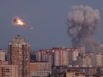 Ukrainian servicemen shoot down a Russian missile as smoke rises from the city during a Russian missile strike, amid Russia's attack on Ukraine, in Kyiv.