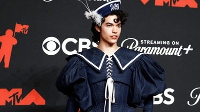 Conan Gray stole the show in a ruffled, laced-up ensemble designed by Erik Charlotte, inspired by the nautical theme of his new album Wishbone. His floor length gown featured a puff-sleeved jacket, structured corset and a skirt with layered ruffles, paired with white platform boots and a matching sailor hat. (REUTERS)