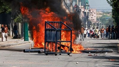 A police barricade is seen in front of a fire set alight by demonstrators during a protest outside the Parliament in Kathmandu condemning social media prohibitions by the government. (AFP) A police barricade is seen in front of a fire set alight by demonstrators during a protest outside the Parliament in Kathmandu condemning social media prohibitions by the government. (AFP)