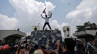A demonstrator waves a flag as he stands atop a vehicle near the entrance of the Parliament during a protest against government’s decision to block several social media platforms. (REUTERS)