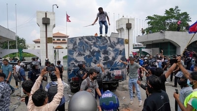 Protesters surround an armoured vehicle of a police during clashes outside the Parliament building in Nepal's Kathmandu (AP) Protesters surround an armoured vehicle of a police during clashes outside the Parliament building in Nepal's Kathmandu (AP)