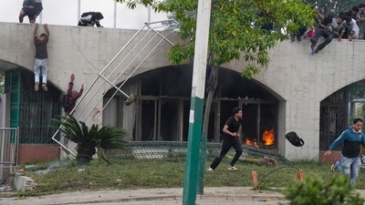 Protesters were seen jumping from a burning building during clashes with riot police in Kathmandu, Nepal on Monday (AP) Protesters were seen jumping from a burning building during clashes with riot police in Kathmandu, Nepal on Monday (AP)