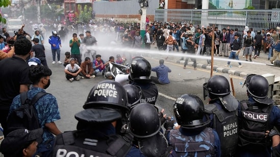 Riot police use water cannon on protesters during clashes outside parliament building in Kathmandu, Nepal (AP)