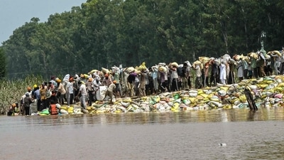 Villagers wade through floodwaters after a rise in the water level of the Ravi River following heavy monsoon rains in the Ghonewala village near Punjab's Amritsar on September 8, 2025. (AFP) Villagers wade through floodwaters after a rise in the water level of the Ravi River following heavy monsoon rains in the Ghonewala village near Punjab's Amritsar on September 8, 2025. (AFP)