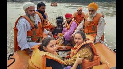 NDRF personnel with evacuated persons during a rescue operation in a flood-affected area of Punjab. (PTI Photo) NDRF personnel with evacuated persons during a rescue operation in a flood-affected area of Punjab. (PTI Photo)