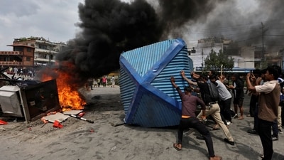 Demonstrators push a police booth to burn it outside Nepali Congress party office during a protest against Monday's killing of 19 people. (REUTERS)