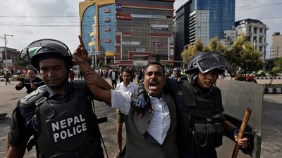 A demonstrator reacts as he is detained by police officers outside the Parliament during a curfew following a protest against corruption and government’s decision to block several social media platforms, in Kathmandu. (REUTERS)