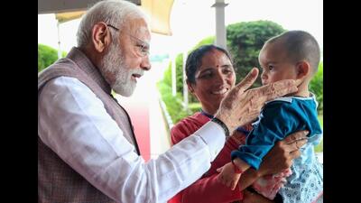 PM Modi with Nikita, infant orphaned during Mandi cloudburst tragedy. (HT Photo) PM Modi with Nikita, infant orphaned during Mandi cloudburst tragedy. (HT Photo)