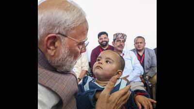 Prime Minister Narendra Modi with a child survivor during a meeting with flood-affected people of Kangra in Himachal Pradesh on Tuesday. (PTI Photo) Prime Minister Narendra Modi with a child survivor during a meeting with flood-affected people of Kangra in Himachal Pradesh on Tuesday. (PTI Photo)