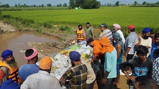 Farmers plugging breach of the Dhussi bundh at village Burj Tehal Das.