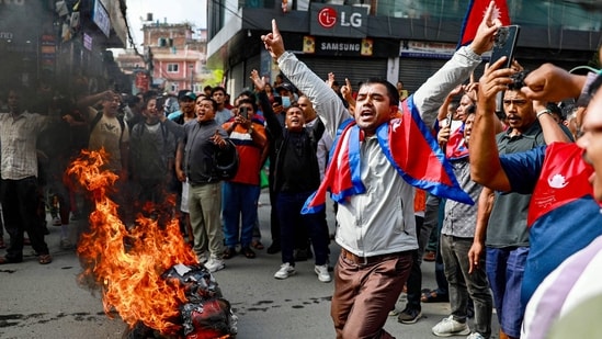 People displaying Nepal's national flag burn tyres during a demonstration to condemn the police's deadly crackdown on protesters in Kathmandu on September 9, 2025. (Prabin Ranabhat/AFP Photo)