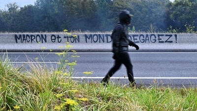 A protester walks past a graffiti reading "Macron and your world, get lost!" as protesters block the Cadix viaduct during a demonstration as part of the "Bloquons tout" ("Let's block everything") protest movement (AFP) A protester walks past a graffiti reading "Macron and your world, get lost!" as protesters block the Cadix viaduct during a demonstration as part of the "Bloquons tout" ("Let's block everything") protest movement (AFP)