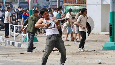 A protester wields a firearm as demonstrators gather outside the Singha Durbar palace complex during a protest to condemn the police's deadly crackdown on demonstrators in Kathmandu on September 9, 2025, a day after demonstrations over social media prohibitions and corruption by the government. (Prabin Ranabhat/AFP)