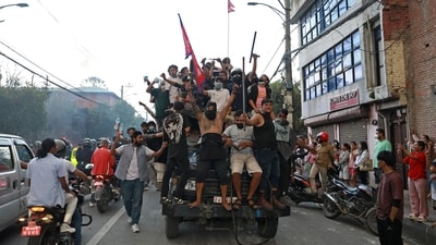 Protesters carry Nepal's national flag as they ride a police truck outside the President House in Kathmandu on September 9, 2025, a day after demonstrations over social media prohibitions and corruption by the government. (Prabin Ranabhat/AFP)