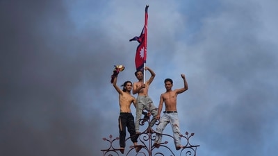 Protesters celebrate standing at the top of the Singha Durbar, the seat of Nepal's government's various ministries and offices, after it was set on fire during a protest. (Niranjan Shrestha/AP)
