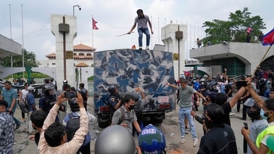 Protesters surround an armored vehicle of a police during clashes outside the Parliament building in Kathmandu, Nepal. (AP)