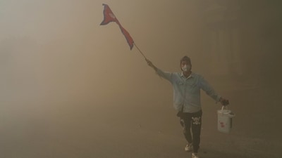 A protester celebrates at the Singha Durbar after it was set on fire during a protest against social media ban and corruption in Kathmandu, Nepal. (Niranjan Shrestha/AP)