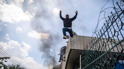 Demonstrators jump from the entrance wall of Nepal's Parliament building during a protest in Kathmandu. (Prabin Ranabhat/AFP)