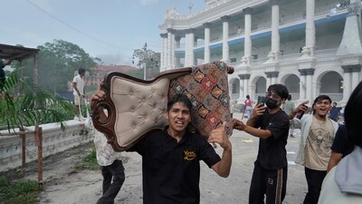 A protester carries a chair from the Singha Durbar during a protest against social media ban and corruption in Kathmandu. (Niranjan Shrestha/AP)