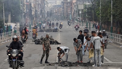 Nepali army soldiers clear debris from a road near the Singha Durbar office complex that houses the Prime Minister's office and other ministries, following protests. (Navesh Chitrakar/Reuters)