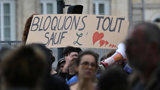 A protester in Rennes holds a placard reading "Let's block everything except Love" during a demonstration as part of the "Bloquons tout" ("Let's block everything") protest movement in France.(Damien Meyer/AFP)