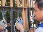 AAP MP Sanjay Singh speaking to National Conference president Farooq Abdullah from across the gate of the guest house in Srinagar on Thursday. (X)
