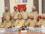 Commissioner of police, Amritsar, Gurpreet Singh Bhullar (centre) and his team with the weapons recovered from the smuggling module, including a 9mm Glock, three .30 bore PX5 pistols, one .32 bore and .30 bore pistol. (HT Photo)