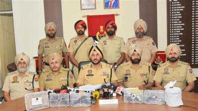 Commissioner of police, Amritsar, Gurpreet Singh Bhullar (centre) and his team with the weapons recovered from the smuggling module, including a 9mm Glock, three .30 bore PX5 pistols, one .32 bore and .30 bore pistol. (HT Photo)